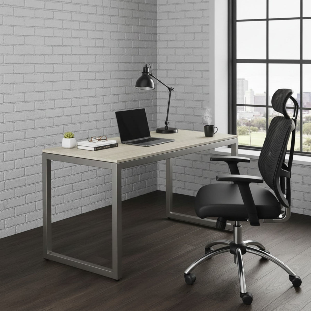 The desk against a white brick wall with a dark task lamp, a laptop and a mug, black chair on a dark timber floor