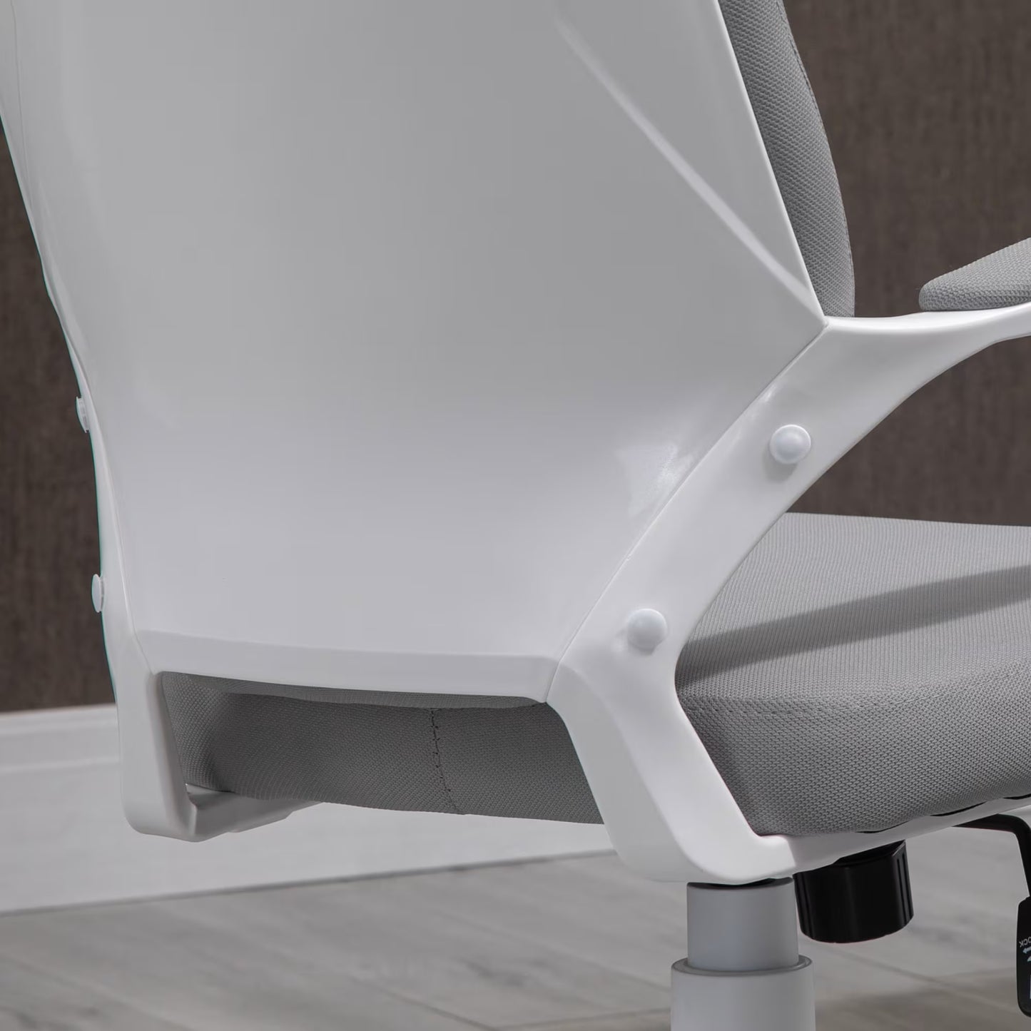 Close-up of a white office chair with gray mesh backrest on a wooden floor.