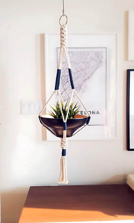Macrame Plant Hanger handcrafted in 100% Ontario cotton rope with navy accents, suspending a black bowl planter.
