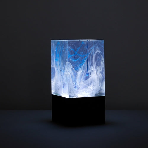Resin block with blue and white abstract design on a black background