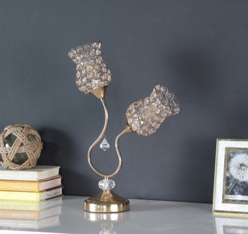Decorative lamp with crystal accents on a surface against a dark gray wall.