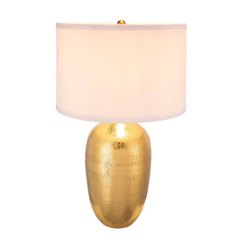 Table lamp with gold textured Aluminum base and white shade on a white background
