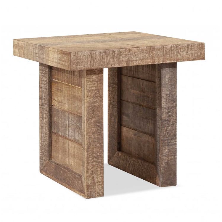 Solid wood butcher-block end table in a warm finish with chunky square legs beside a sofa.