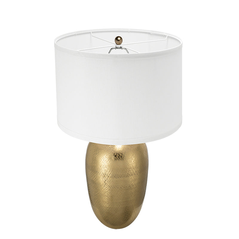 Table lamp with gold base and white shade on a white background