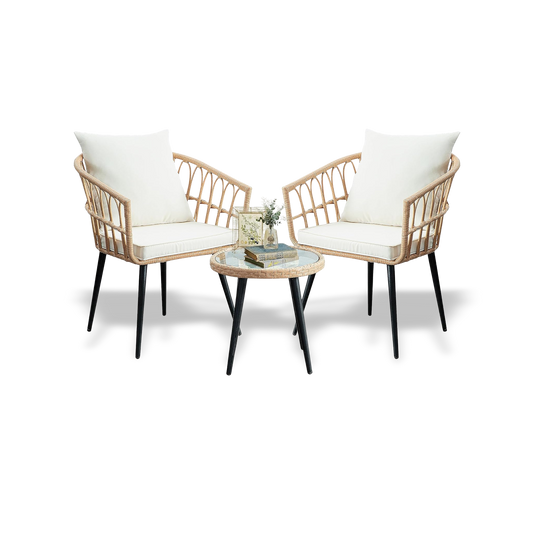 Two wicker chairs with white cushions and a matching table on a white background