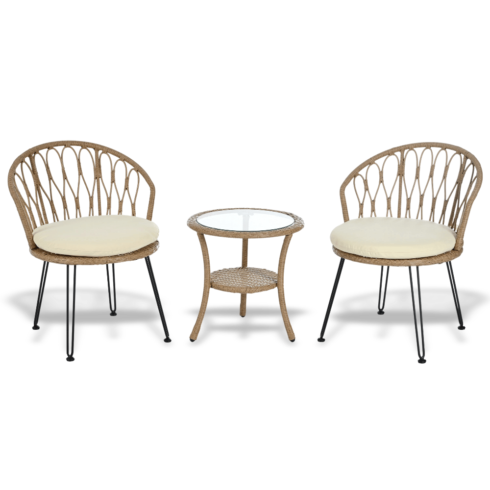 Two wicker chairs with cream cushions and a matching side table on a white background
