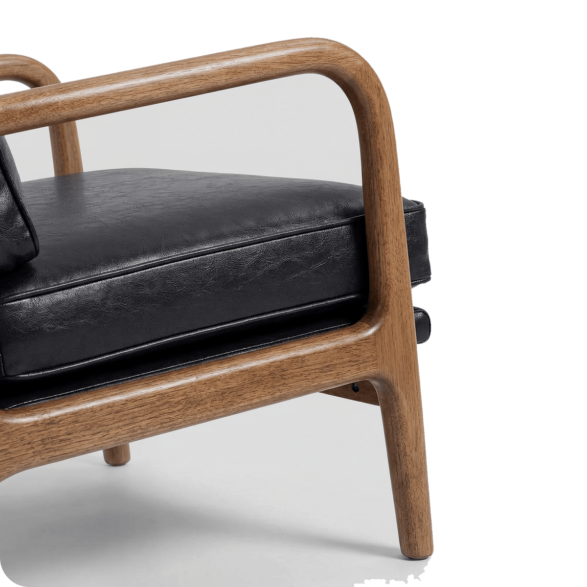 Curved solid wood armrest of the black leather chair (close-up detail)