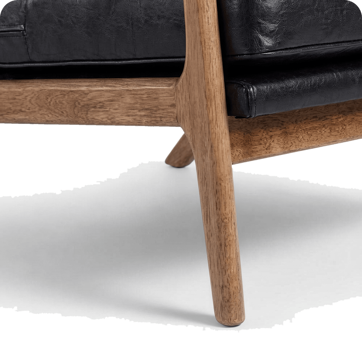 Splayed solid wood leg of the black leather chair (close-up detail)