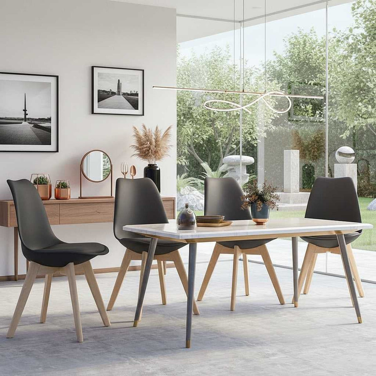 Set of four mid-century modern black plastic-shell dining chairs with wooden legs around a white table.