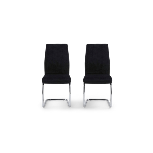 Velvet dining chair pair with channel-stitched backs turned at an angle on a plain #f3f3f3 studio ground