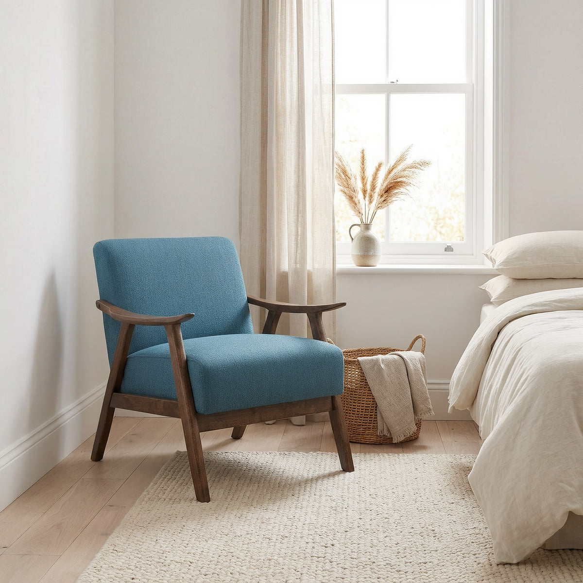 Blue linen accent chair in a bright bedroom reading corner by a sash window