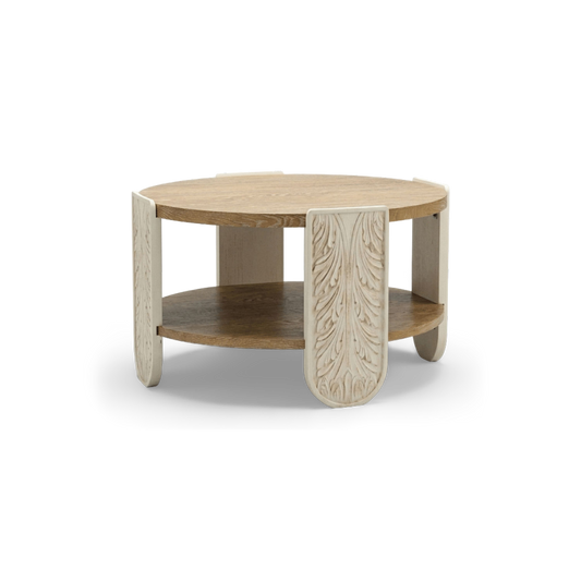 Round two-tier carved wood coffee table with cream carved leg panels and oak top, shown at an angle