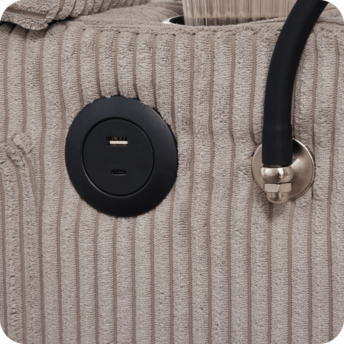 USB charging ports set in the arm of the corduroy chaise lounge chair (close-up detail)