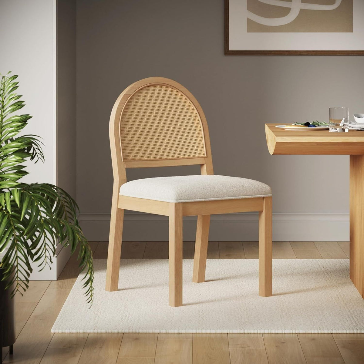 Cane back boucle chair pulled up to a walnut dining table in a bright room