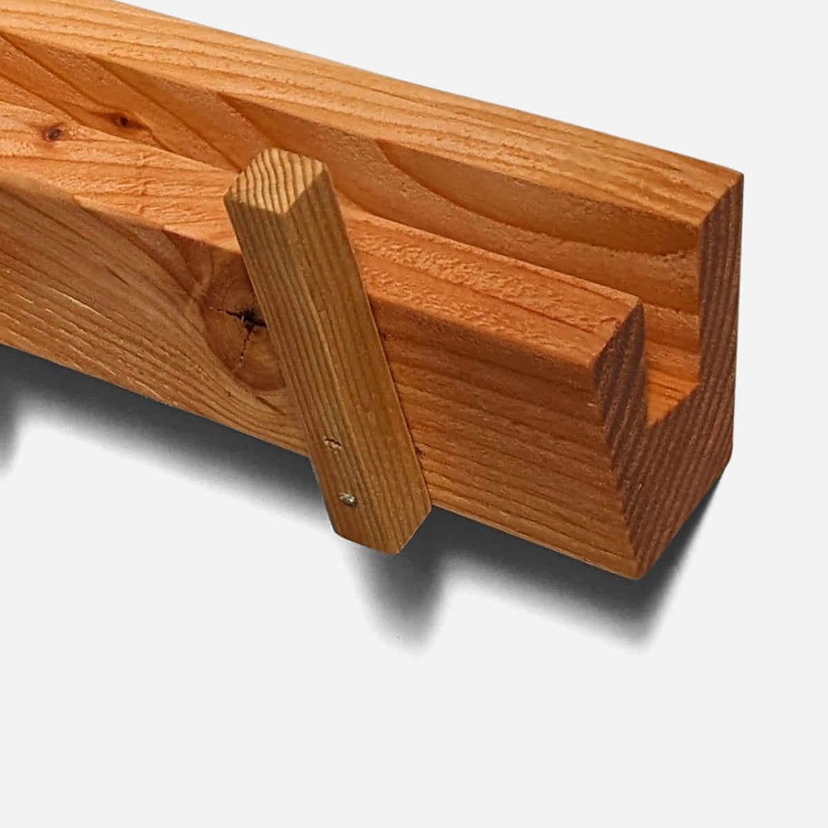 Peg pinned to reclaimed fir beside a dark natural knot (close-up detail)