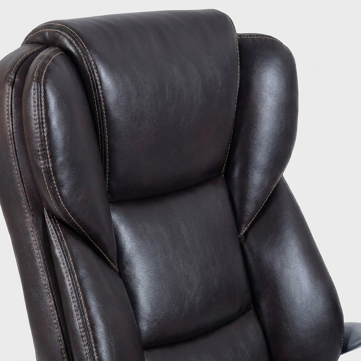Close-up of the zoned, stitched backrest in dark brown faux leather (close-up detail)