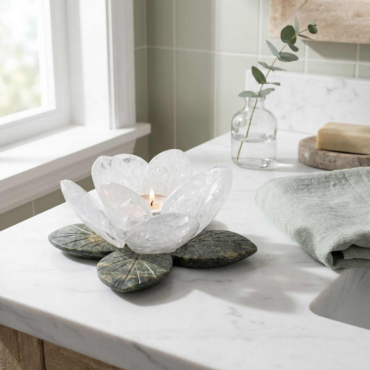 White quartz flower candle holder with a lit tealight on a marble bathroom vanity, closer view (room scene)