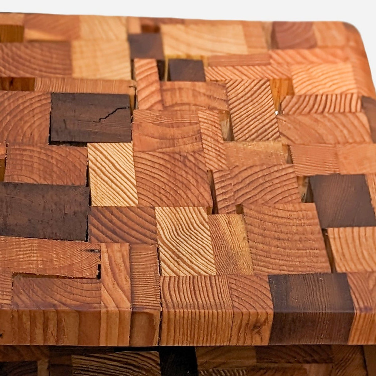 End-grain patchwork top with growth rings and darker weathered blocks, close up