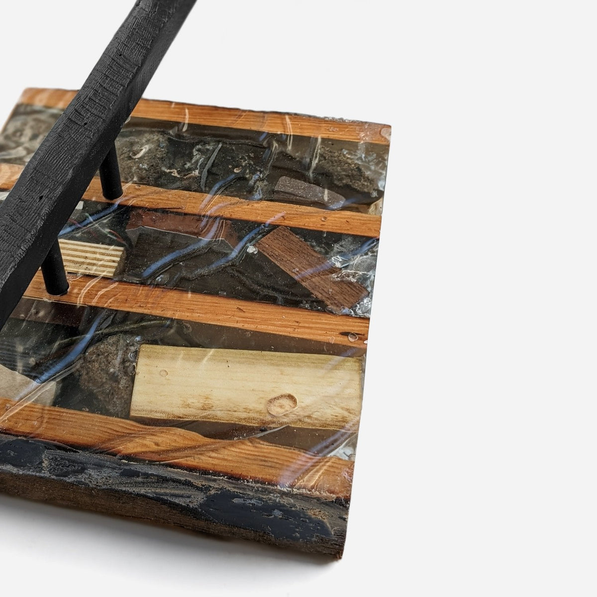 Close-up of a resin-sealed block with fir strips and the charred bar