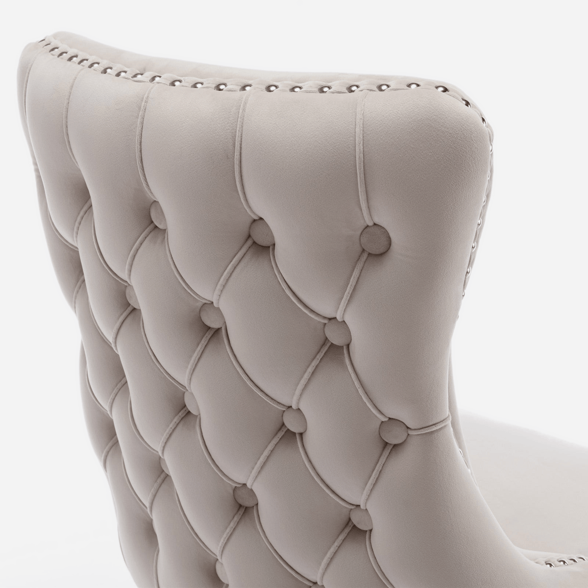 Diamond button-tufted velvet back of a wingback dining chair (close-up detail)