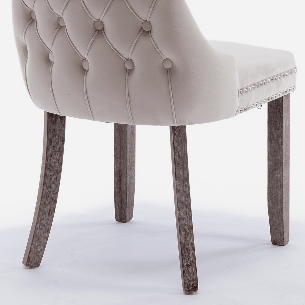 Tapered solid wood leg of a velvet wingback dining chair (close-up detail)