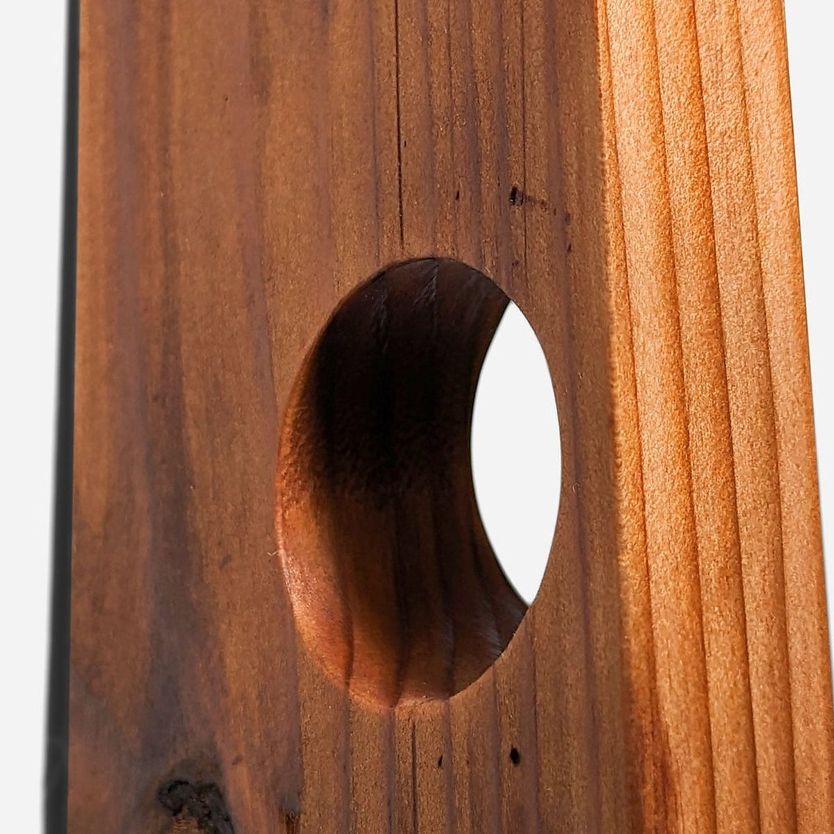 Close-up of a round hole bored through reclaimed fir (close-up detail)