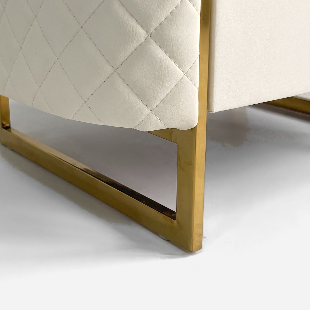 Polished gold sled base corner under the quilted cabinet, close up