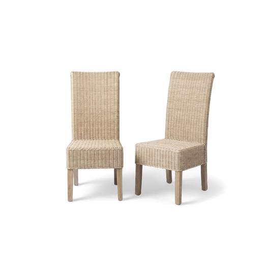 White washed rattan dining chair pair in a rotated three-quarter view (plain studio)