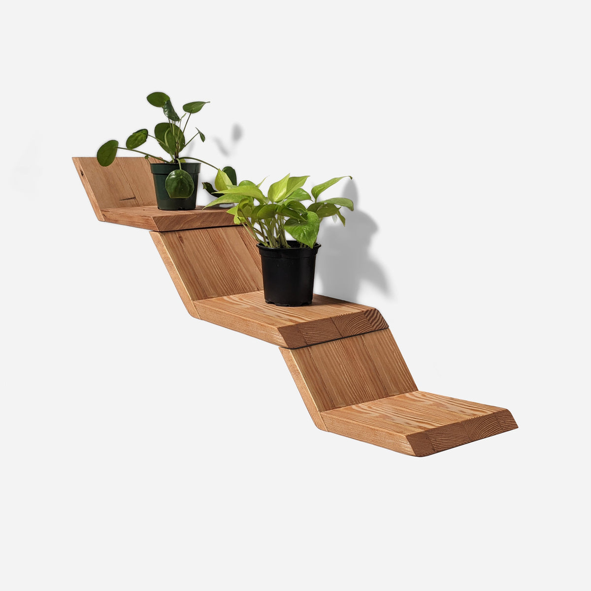 Zig zag shelf, three reclaimed wood shelves stepped up a wall with two potted plants