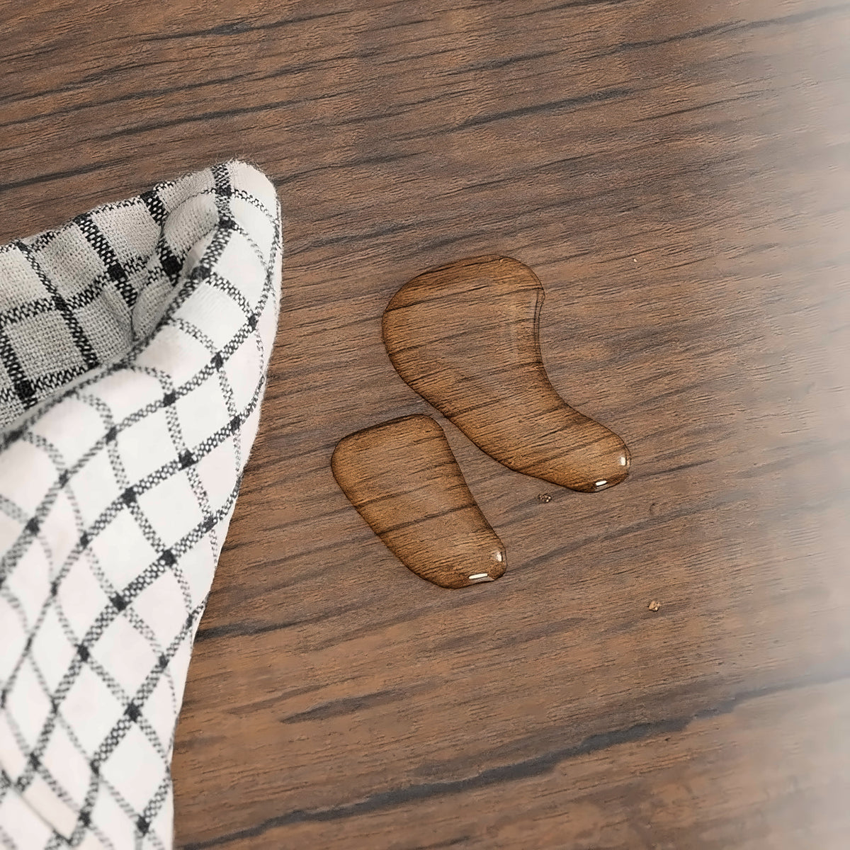 Walnut-tone wood grain top with water beading on the 100 inch tv stand (close-up detail)
