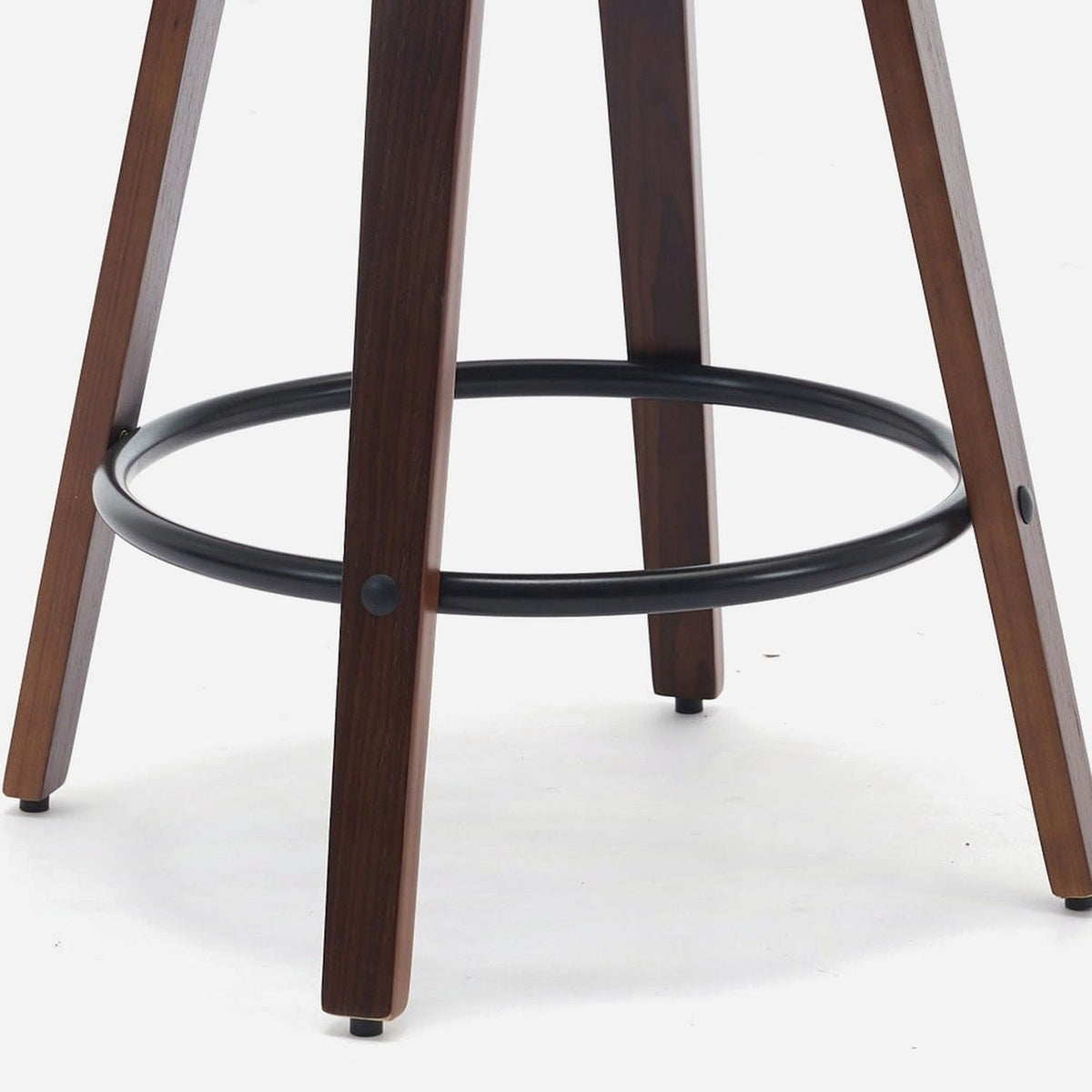 Close-up of the black footrest ring and curved walnut legs of a counter stool