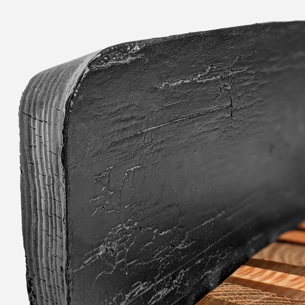Close-up of the raw end-grain edge and black crackle finish