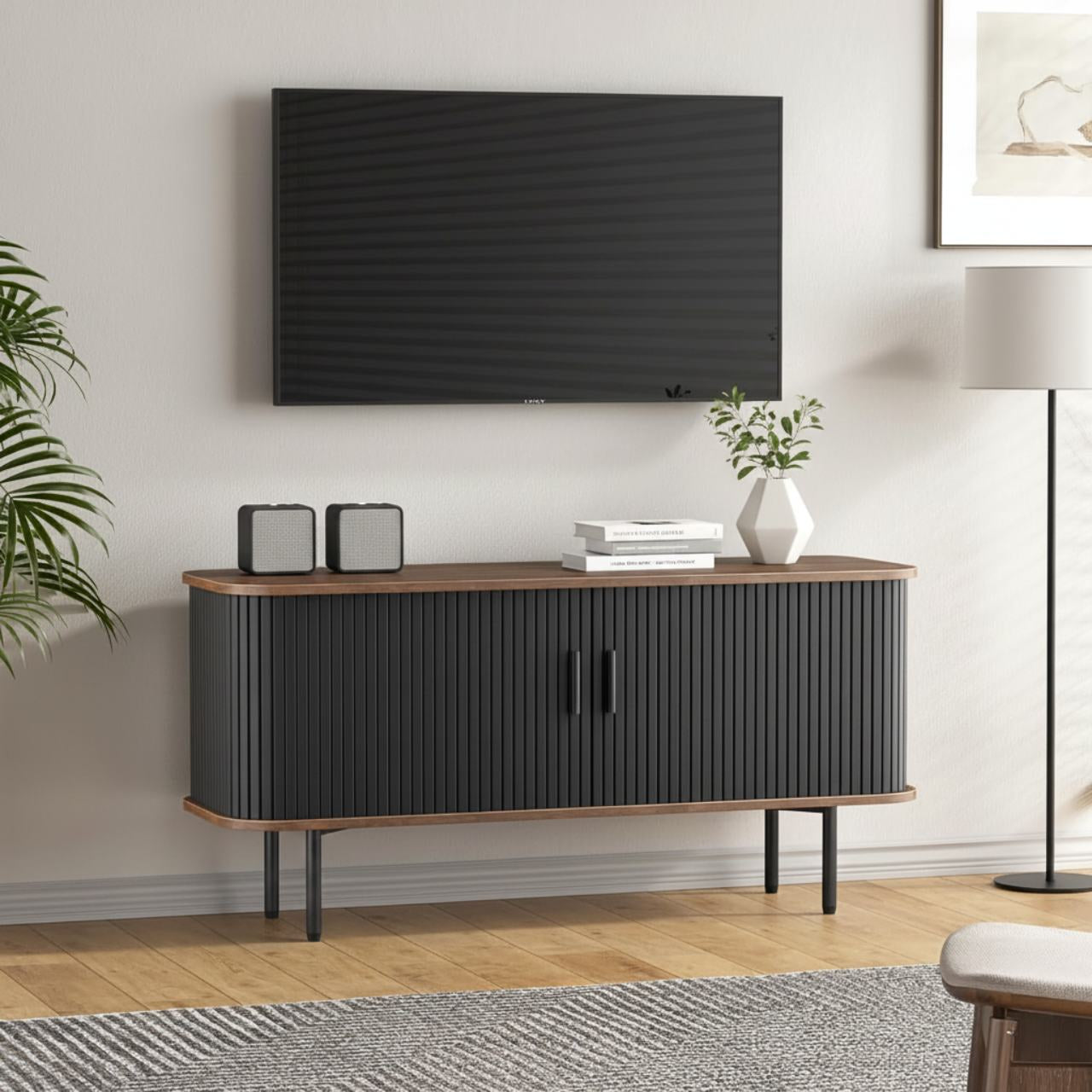 47-inch black sliding-door TV stand with grooved doors, wood trim, and storage under a wall-mounted TV.