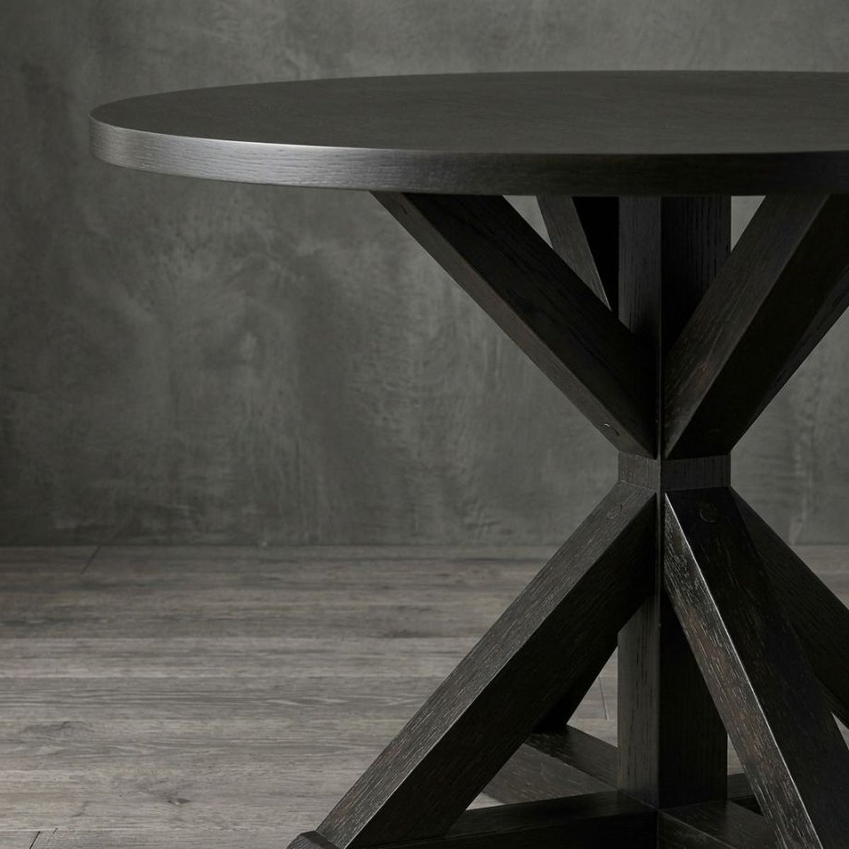Closer view of the black round table base on the concrete floor of the loft