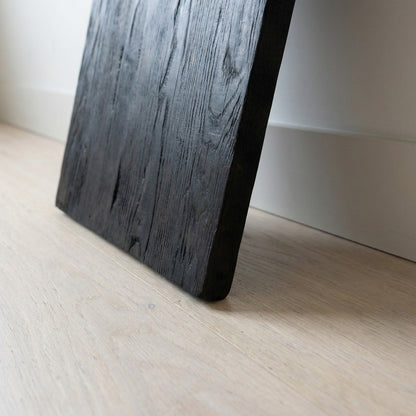 close-up detail of the charred upright foot resting on a pale oak floor