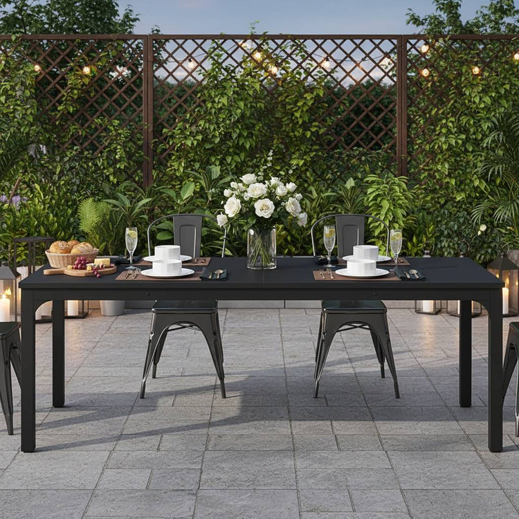 78-inch black rectangular dining table set for six to eight outdoors with a white centerpiece.
