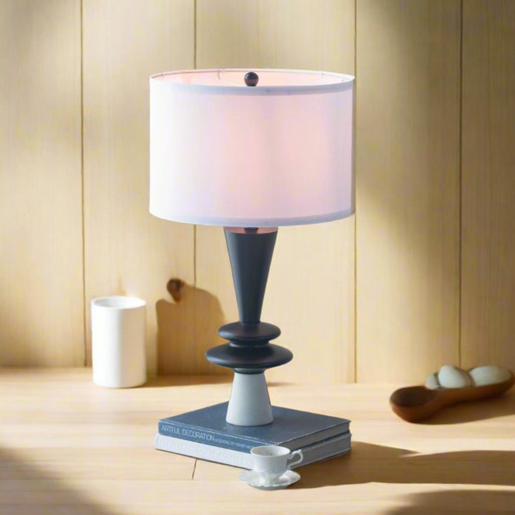 Aluminum Table lamp with a white shade on a wooden surface with a neutral background