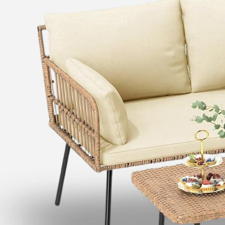 Beige sofa with wicker frame and matching coffee table on a light background