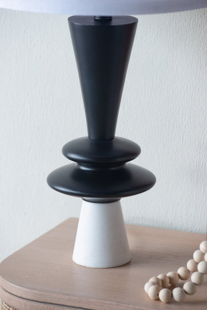 Black and white alaminum lamp on a wooden surface with a white background