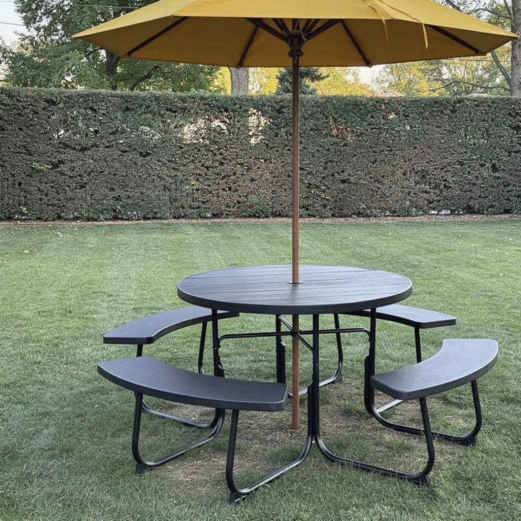 Black outdoor HDPE round picnic table bench set with umbrella hole in backyard.