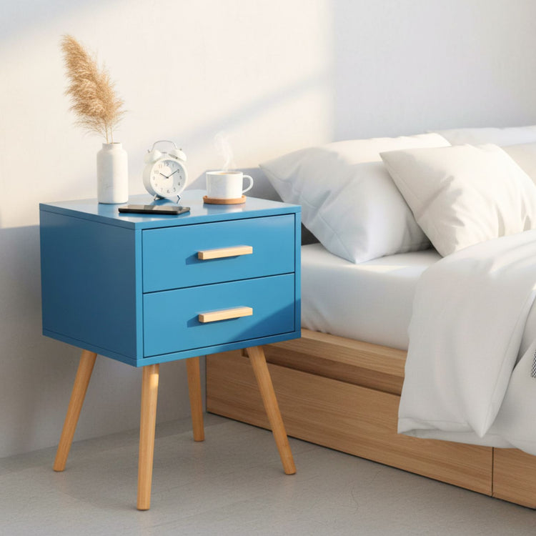 Blue nightstand with wooden legs next to a bed in a bedroom setting
