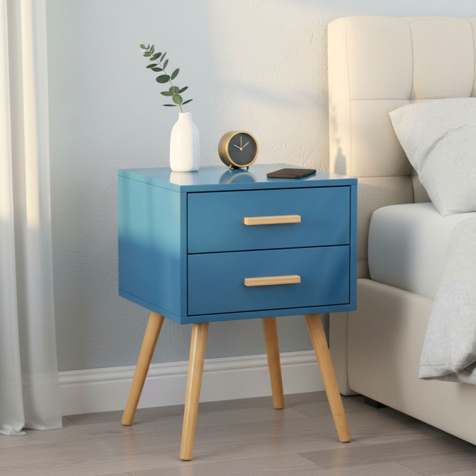 Blue nightstand with wooden legs next to a bed in a bedroom setting
