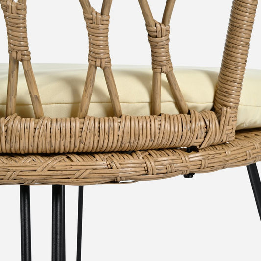 Close-up of a wicker chair with a beige cushion on a white background