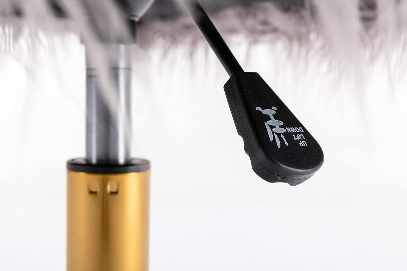 Close-up of height adjustment lever next to a chrome chair base and gold gas lift.