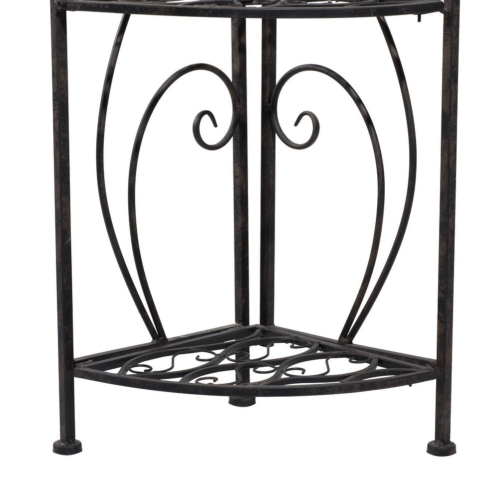 Decorative black metal plant stand with intricate designs on a white background