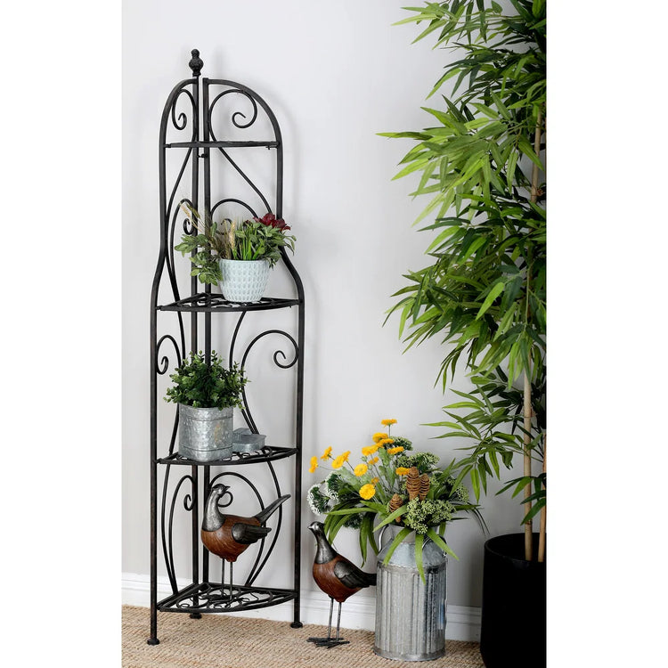 Decorative metal plant stand with plants against a white wall