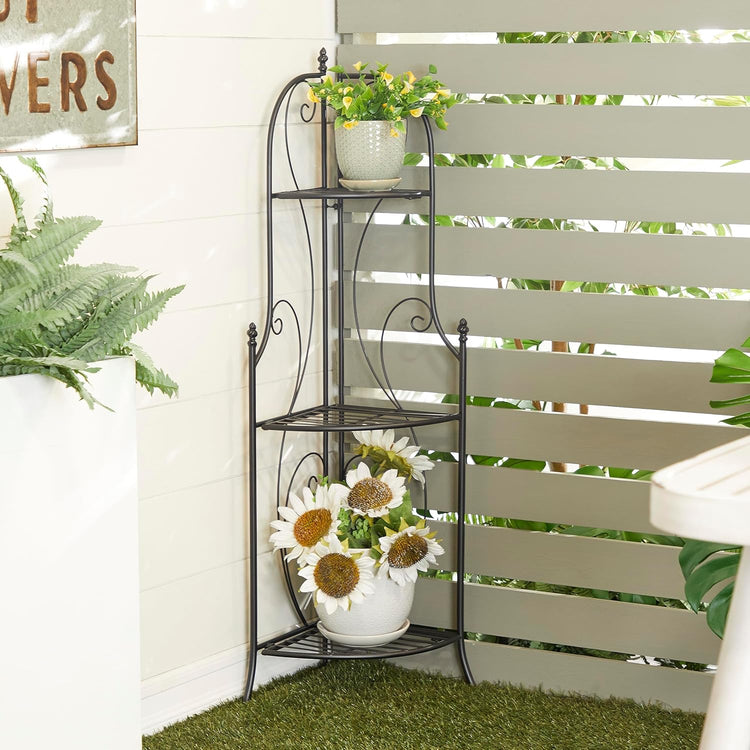 Decorative metal plant stand with potted plants against a white wall.