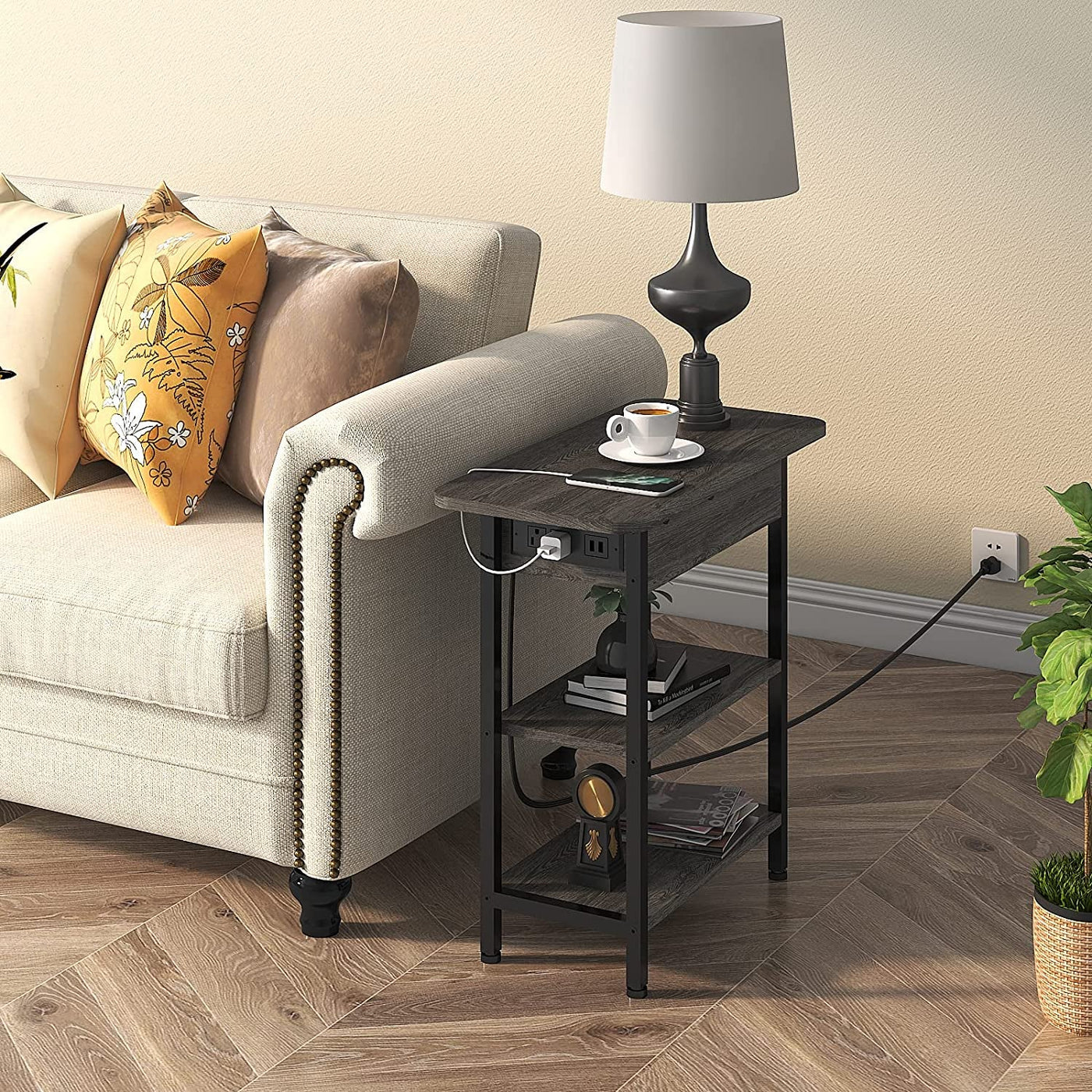 End table with flip-top left side housing charging station, USB ports, and two outlets beside a sofa with a lamp.
