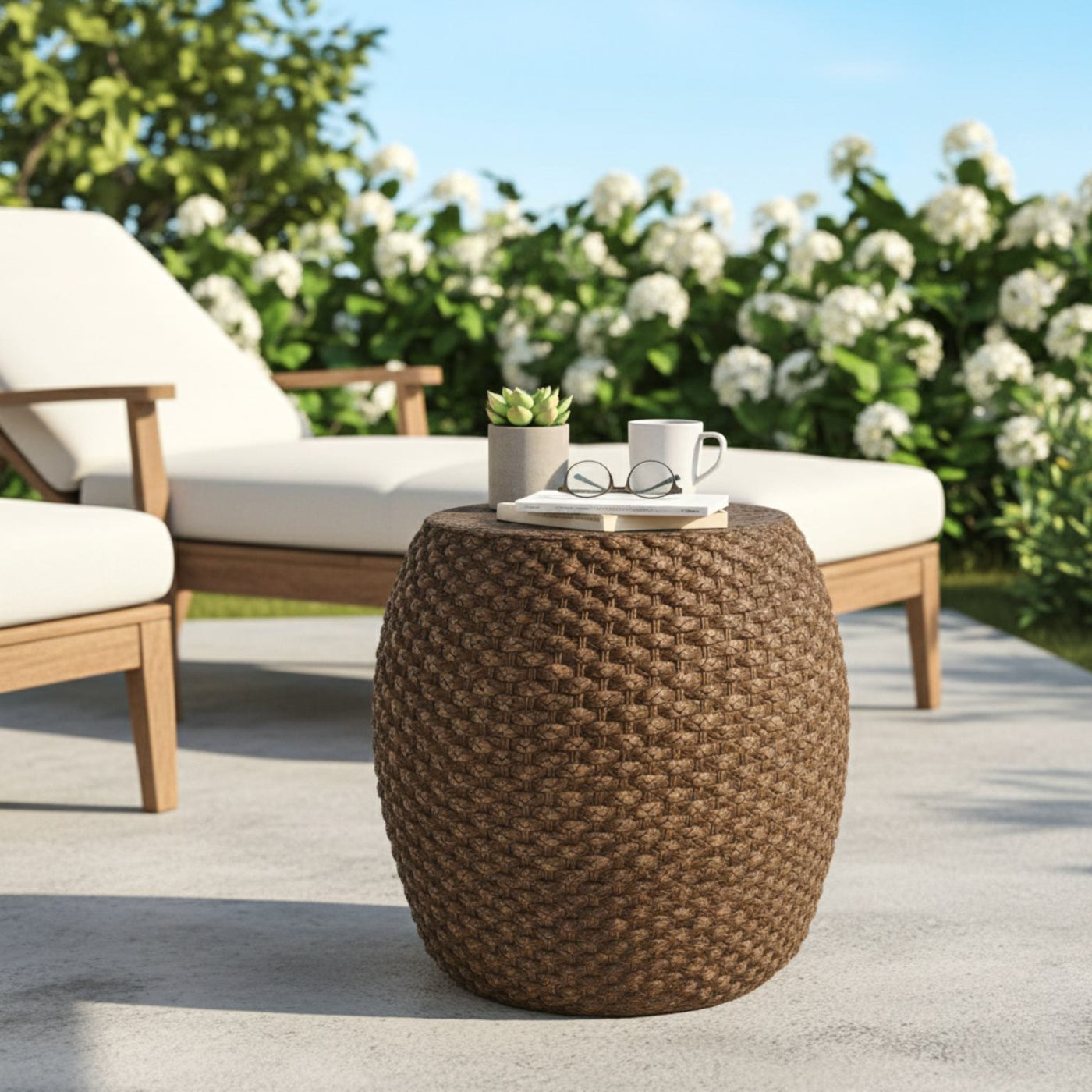 Faux rattan round side table for indoor and outdoor use on a sunny patio, topped with a plant, mug, and glasses.