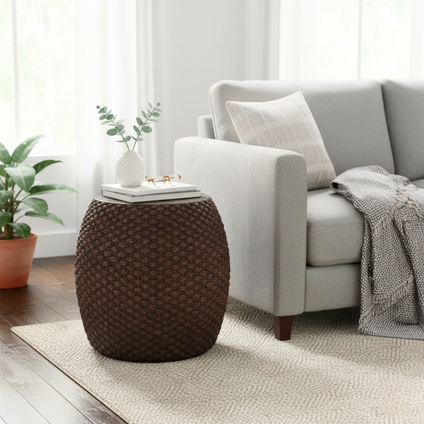 Living room with a textured brown side table, gray sofa, and plants.